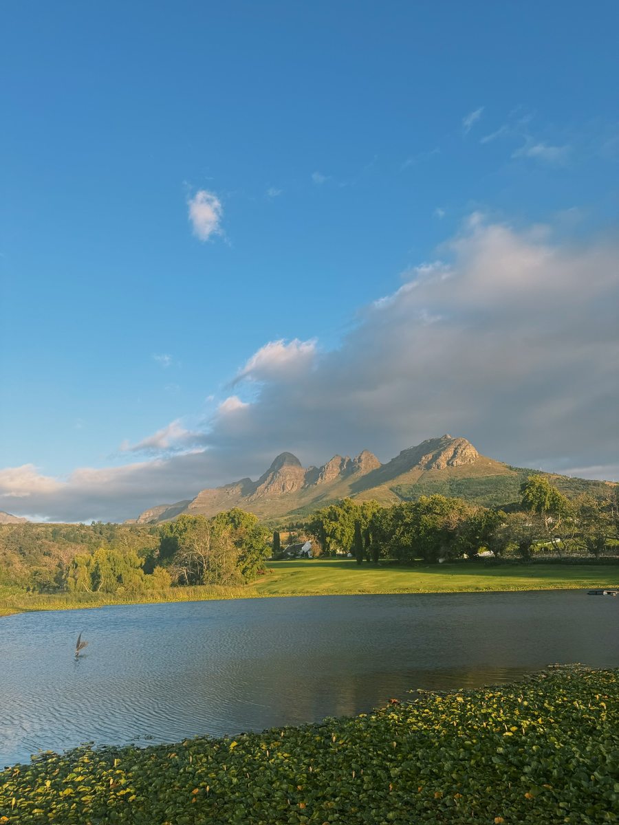 Lake, lawn, and mountains at golden hour near the retreat venue